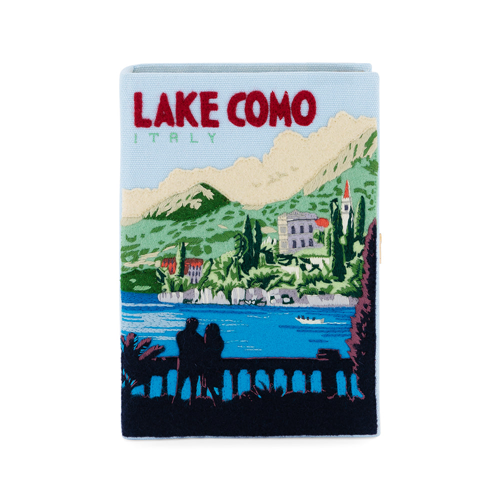 Front view of Lake Como book clutch with embroidered Italian lakeside and LAKE COMO title on light blue background