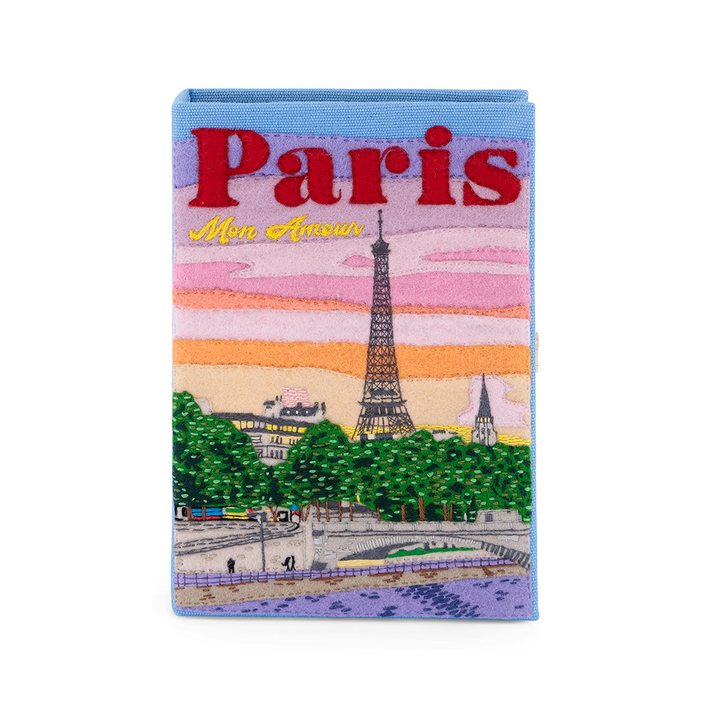 Front view of Paris Mon Amour book clutch showcasing embroidered Eiffel Tower, felt appliqué and the large ‘Paris’ and ‘Mon Amour’ text on a pastel sunset background