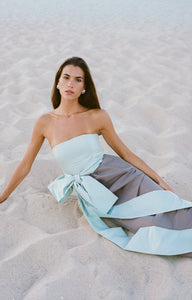 Three-quarter view of Lina Dress in Morning Mist & Mocha showcasing structured bustier and oversized waist bow on seated model