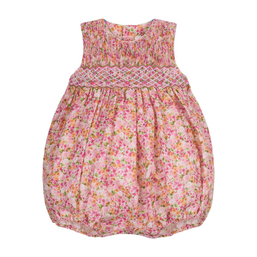 Front view of Isabel Bubble baby bubble showcasing hand-smocked yoke and pink floral linen fabric on white background