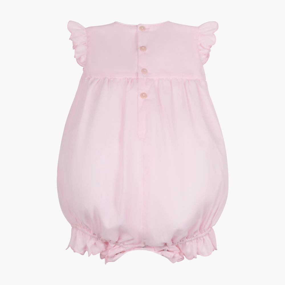 Back view of Constantina Bubble romper in light pink showing back buttons, ruffled cap sleeves and elastic leg openings