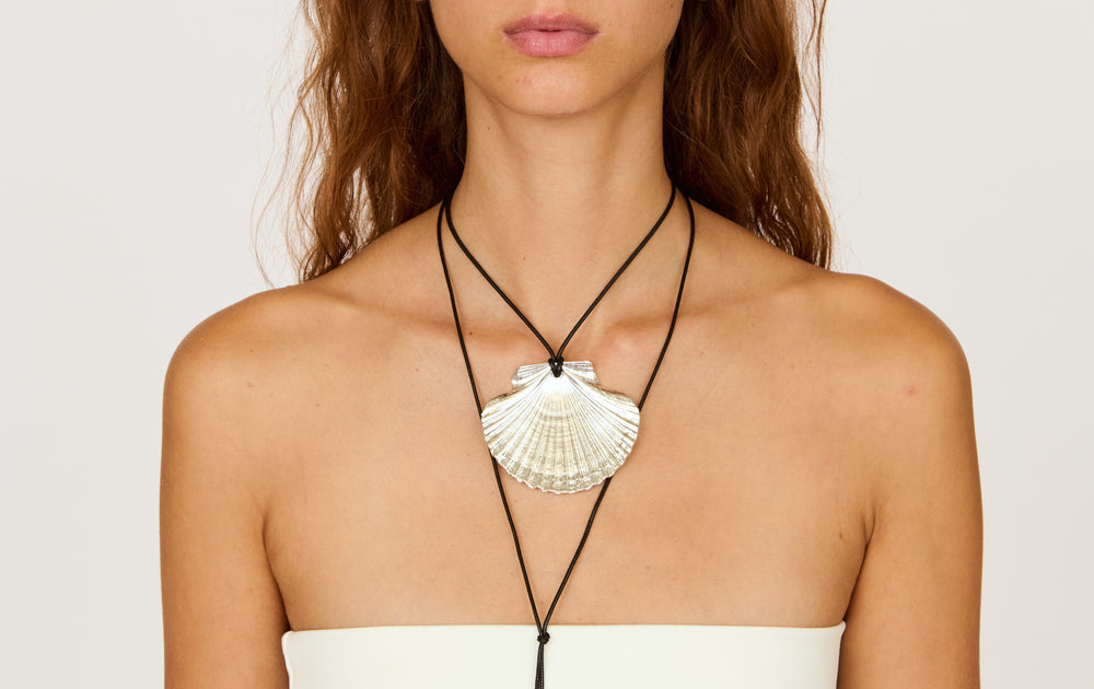 Front view of Venus Wrap Necklace showcasing silver-plated scallop shell pendant on adjustable black cord on white background