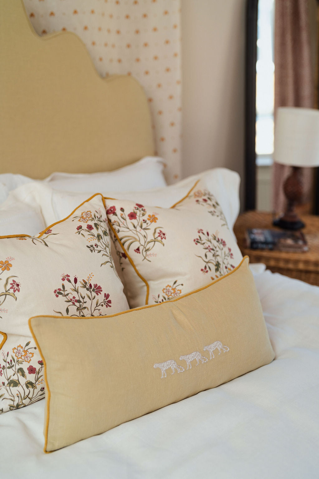 Front view of Flax & Field Flower Print Cushion in Scarlet showcasing floral linen and ochre piping on a styled bed