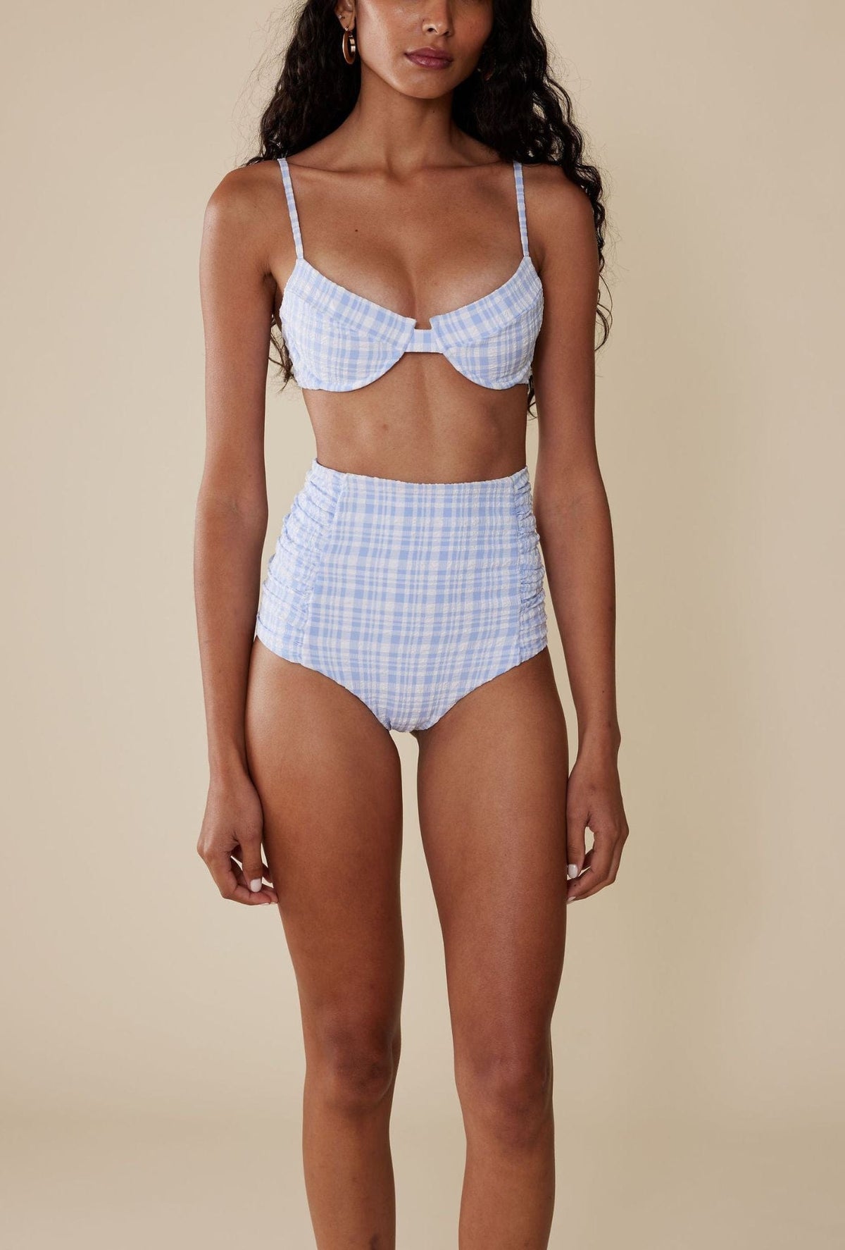 Front view of The Luisa Bottom in Birdie blue gingham, high-rise with ruched sides on beige background