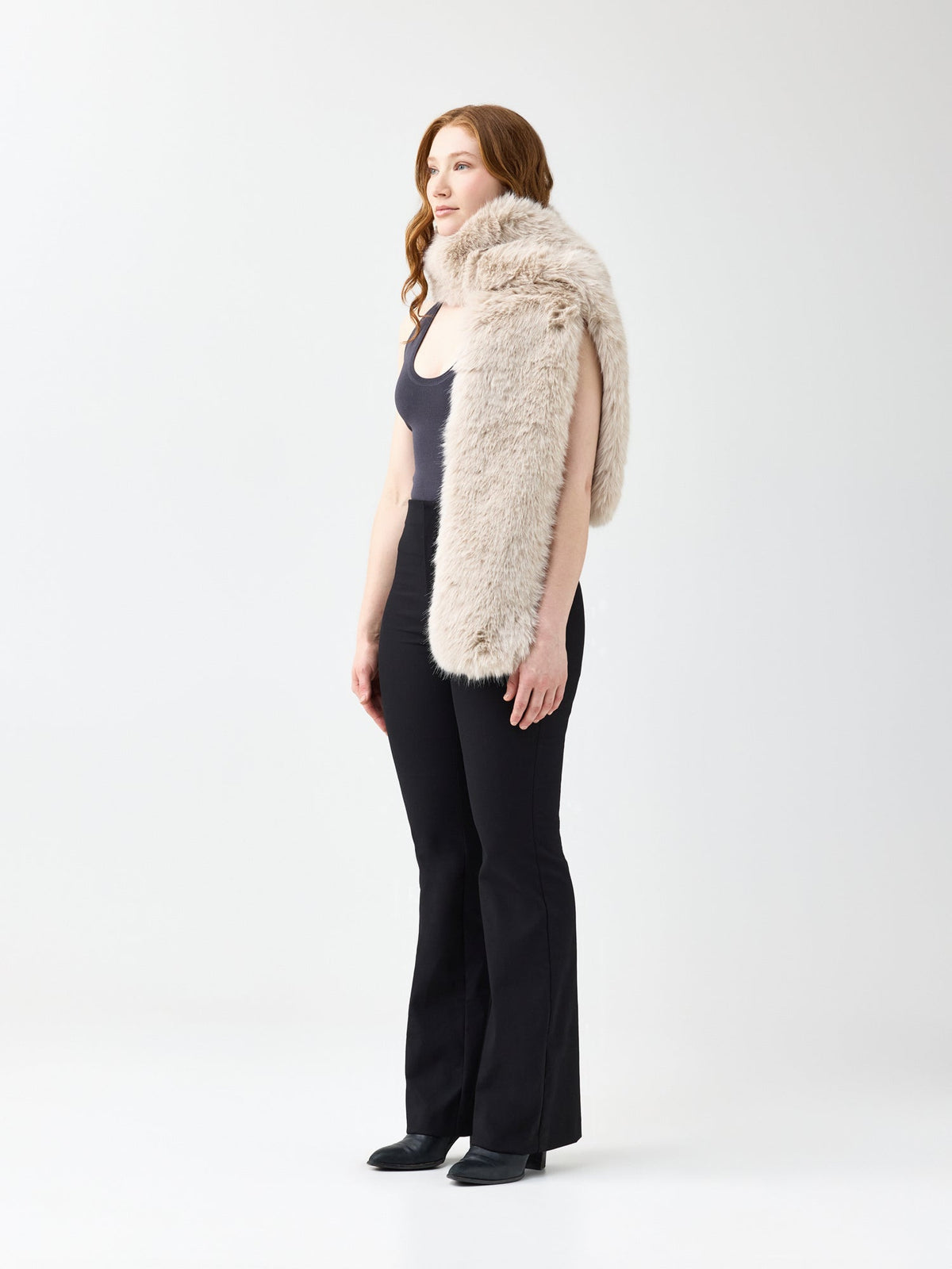 Woman wearing a beige faux fur scarf on a white background