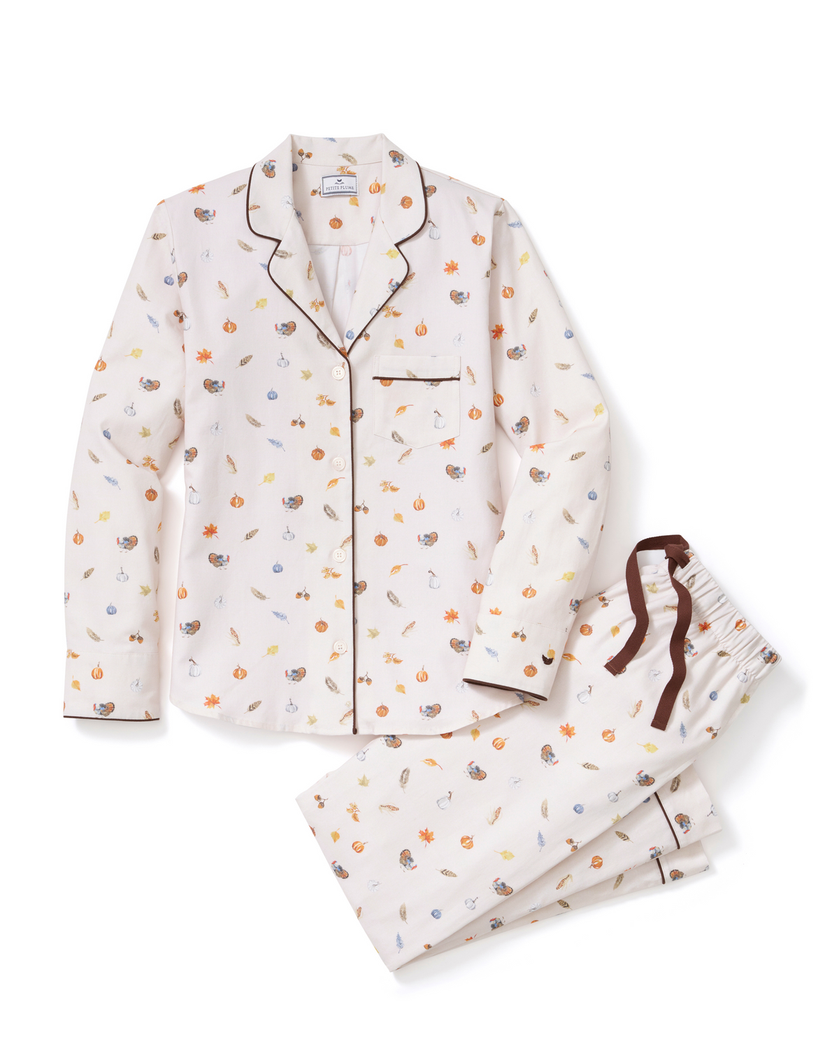Flat lay of twill pajama set in Thanksgiving Traditions with navy piping, pearl buttons, and drawstring trousers on white background
