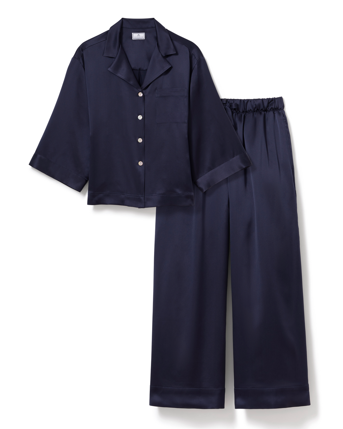 Flat lay of The Olivia Wide Leg Silk Pajama Set in Navy showcasing three-quarter sleeves and wide-leg trousers on white