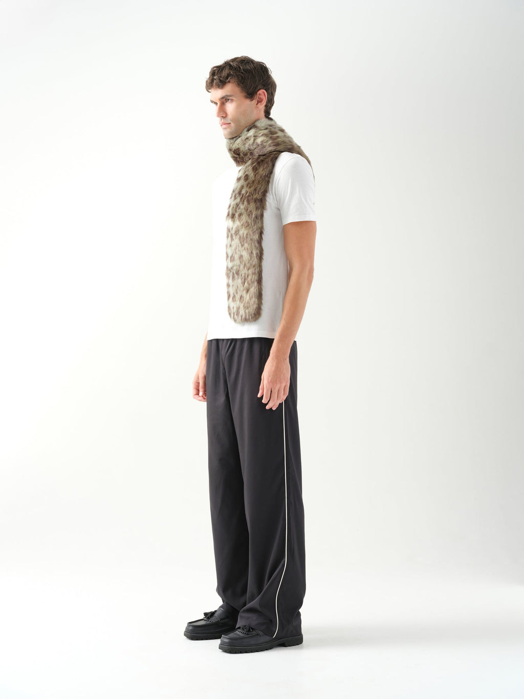 A model in three-quarter profile wearing a long green leopard patterned faux fur scarf.