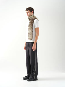 A model in three-quarter profile wearing a long green leopard patterned faux fur scarf.
