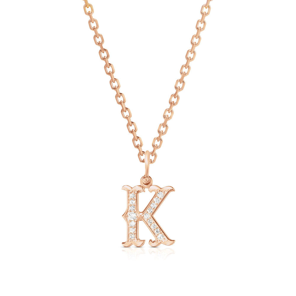 Front view of Western K initial pendant in 14k rose gold on chain with pavé diamond accents on white background