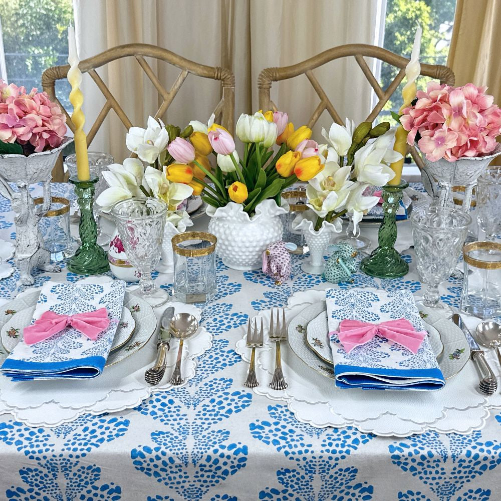 Elegant table setting with floral centerpieces, blue and white tablecloth, and decorative napkins. Vegan leather easy clean 
white placemats