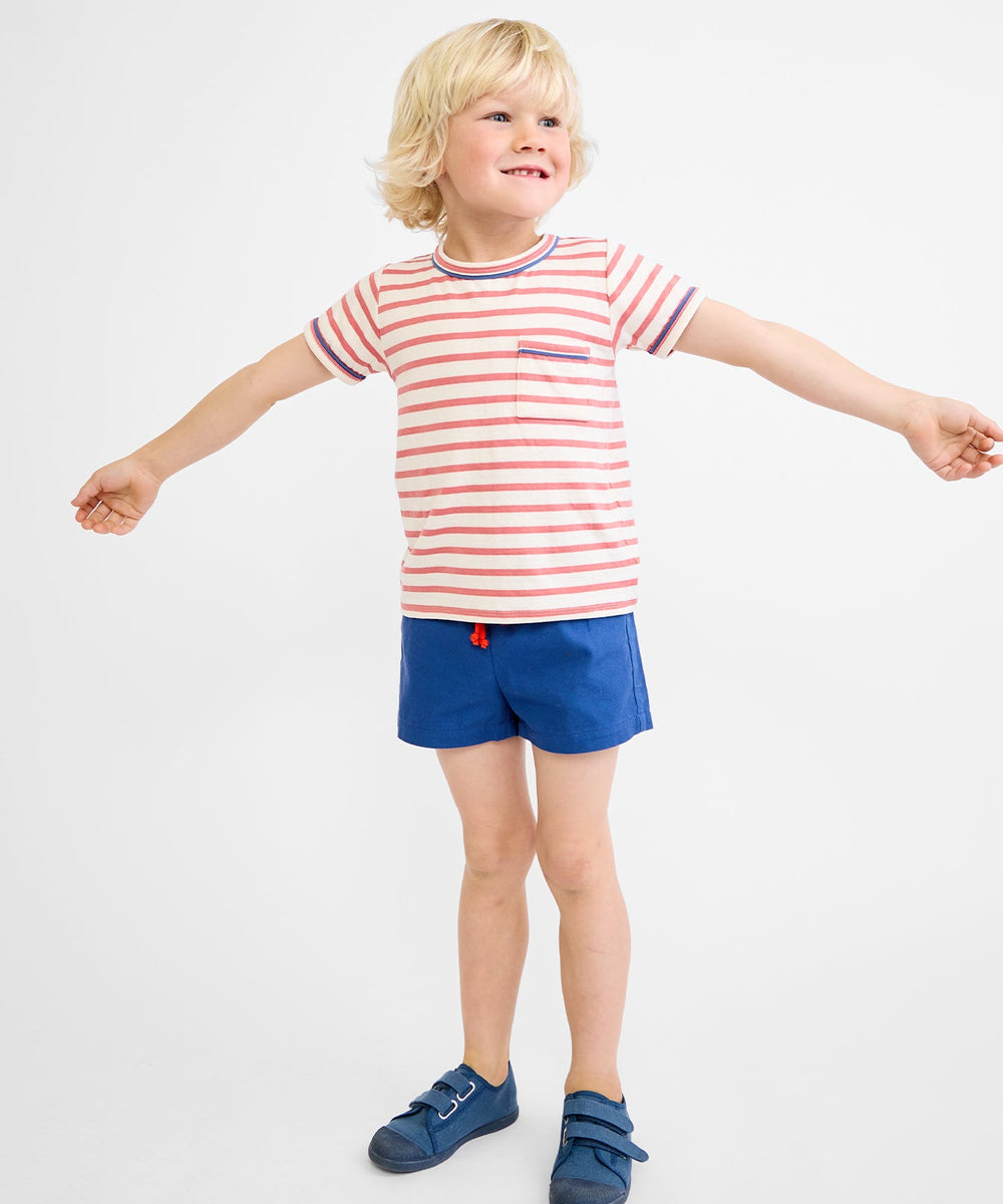 Front view of Willie T‑shirt in nautical red stripe on child model showcasing chest pocket and contrast neck and sleeve piping on white background