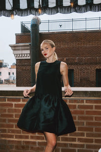 The Windsor Dress has a sleeveless silhouette with a crew neckline, dropped waist with bubble skirt.