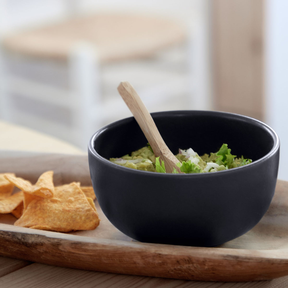 Close-up front view of Pacifica seed grey fruit bowl with matte finish and scalloped rim, filled with guacamole and chips
