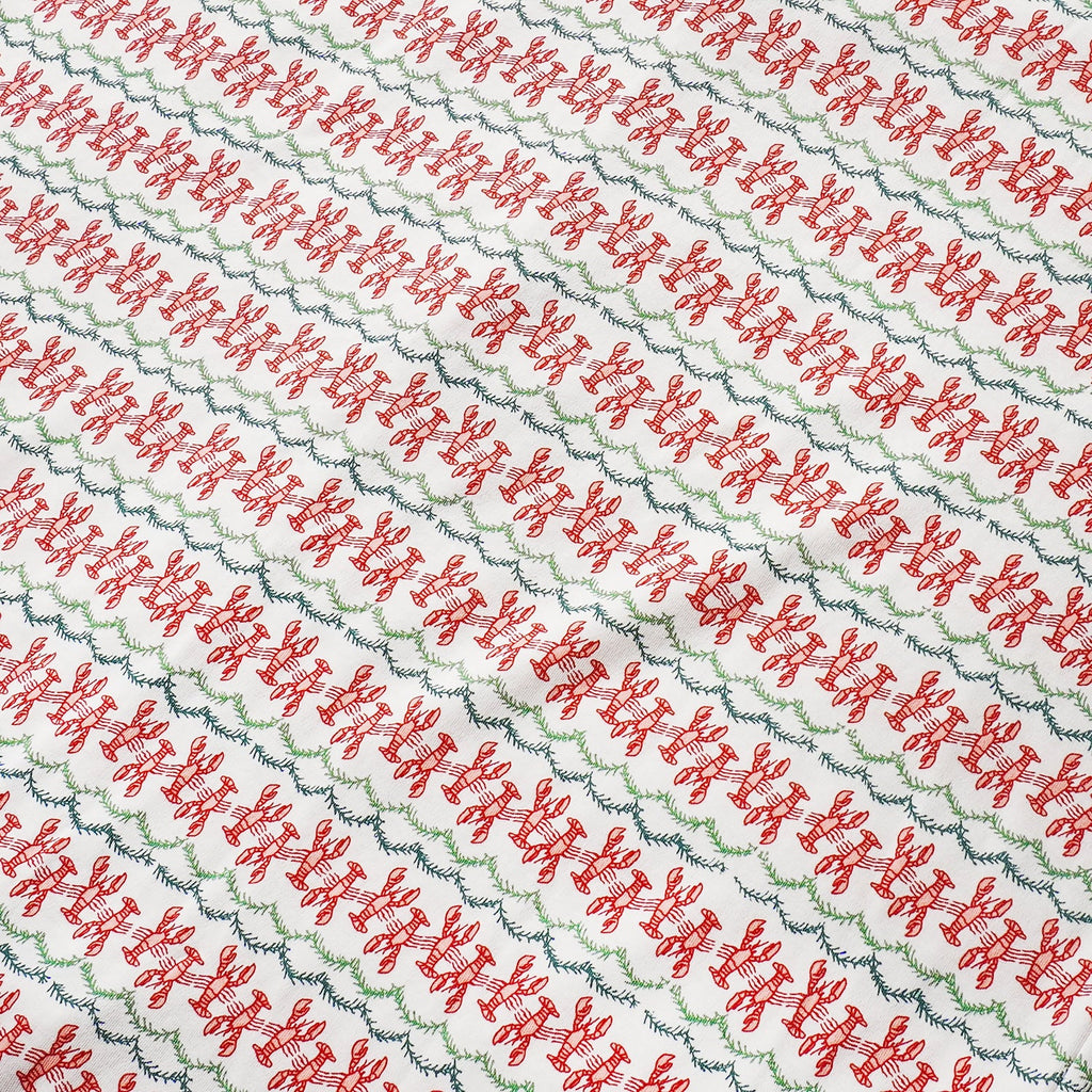 Close-up view of Christmas Lobsters Lounge Pants showcasing red lobster and green evergreen garland print on white fabric