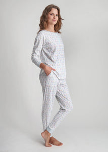 Three-quarter view of Holiday Harbor women’s henley pajama set in a light color with festive sailboat print, gray studio background