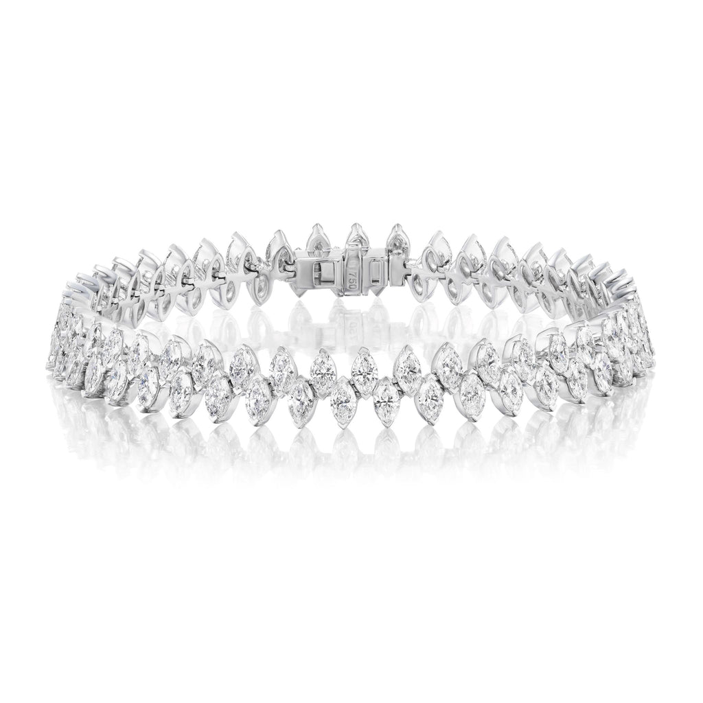 The Alternating Marquise Diamond Tennis Bracelet in White Gold features two rows of SI clarity marquise diamonds, beautifully set in 18k white gold and elegantly displayed on a white reflective surface.