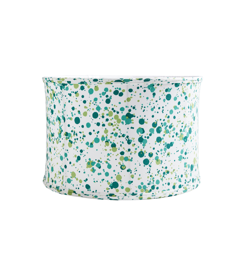 Front view of Spatter drum shade showcasing green paint-splatter pattern on white fabric against black background