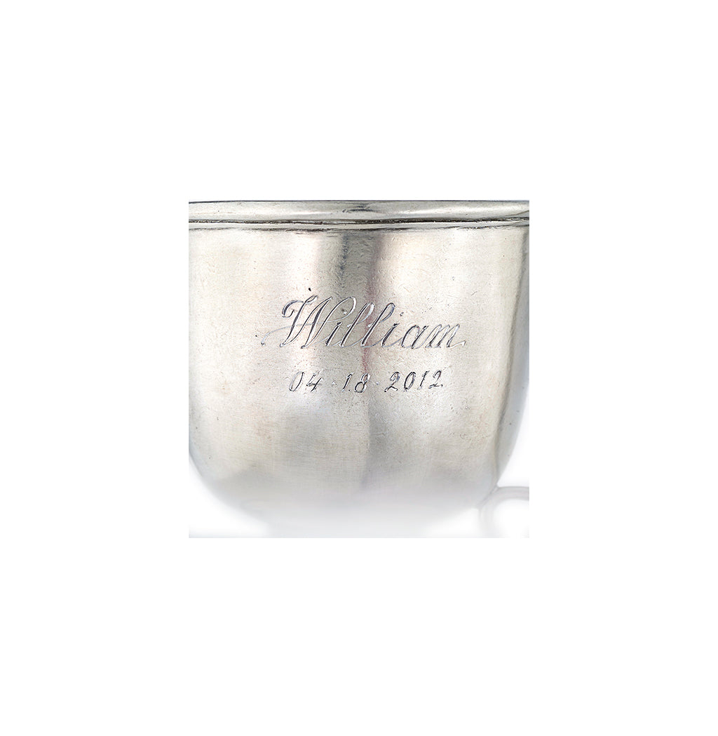 Close-up front view of Match pewter baby cup showing engraved name William and date 04 18 2012 on white background