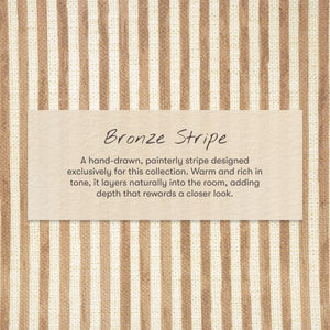 Close-up of All-Stages Bassinet Sheet in Autumn Stripe featuring warm bronze and cream vertical stripes with Bronze Stripe label