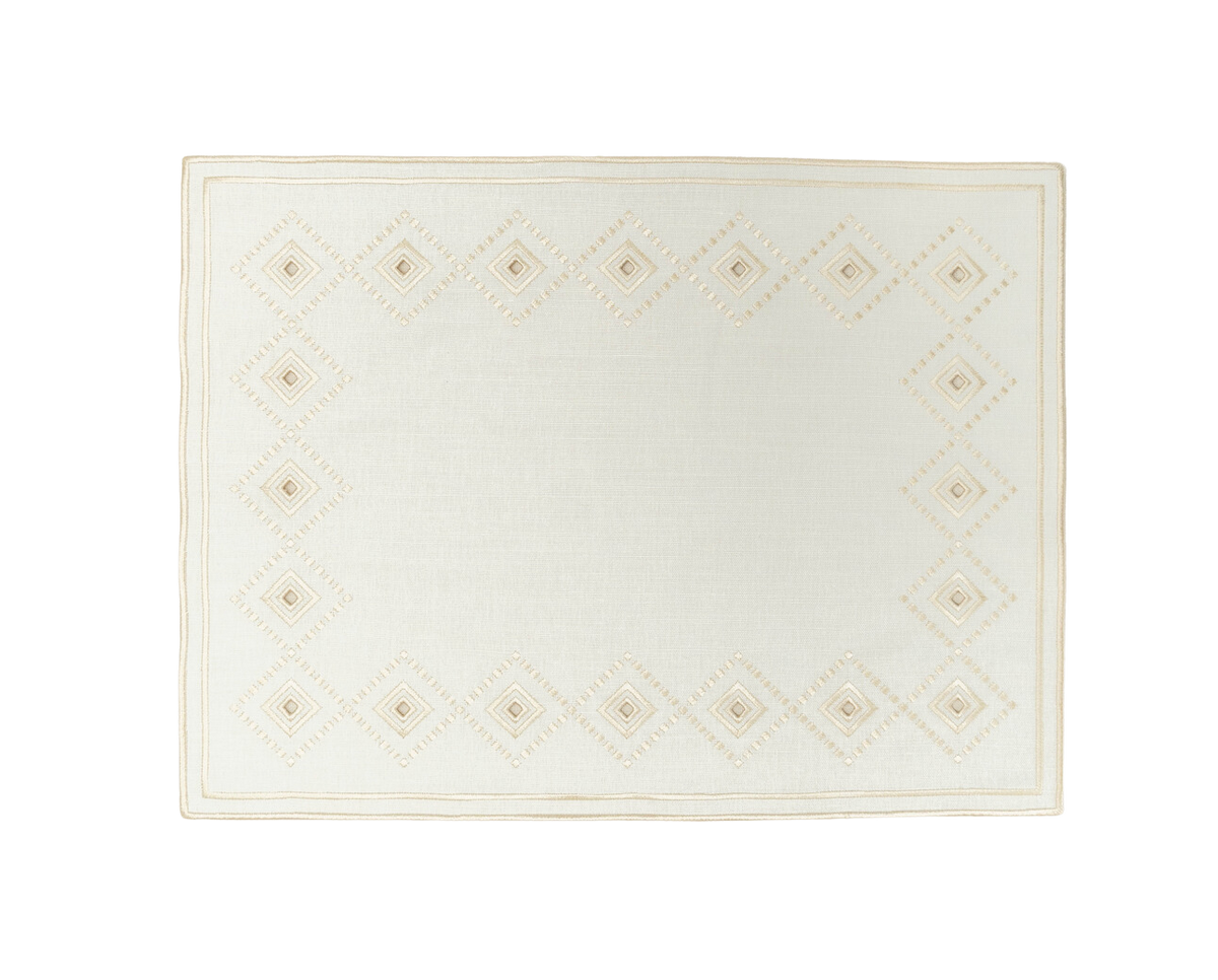 Top view of Ojete Placemat in Ivory showcasing a subtle diamond pattern and bordered design on a black background
