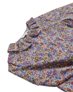 Floral patterned shirt with ruffled collar on a white background