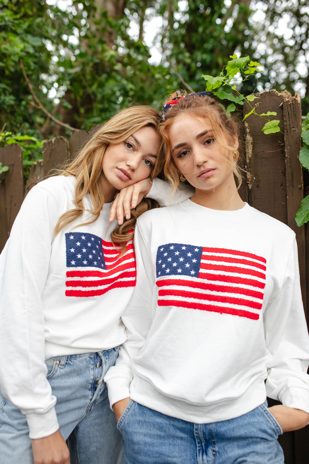 Front view of American Flag Sweatshirt showcasing chenille flag artwork on two models outdoors
