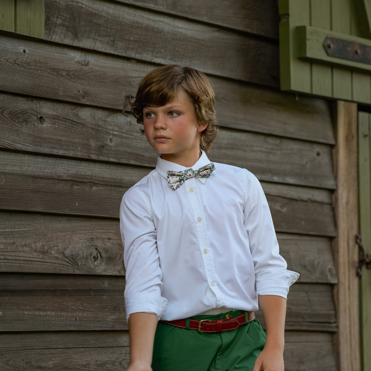 Boys’ Baker Bow Tie in Regent Wreaths, a festive red and green holiday print on a classic white background.