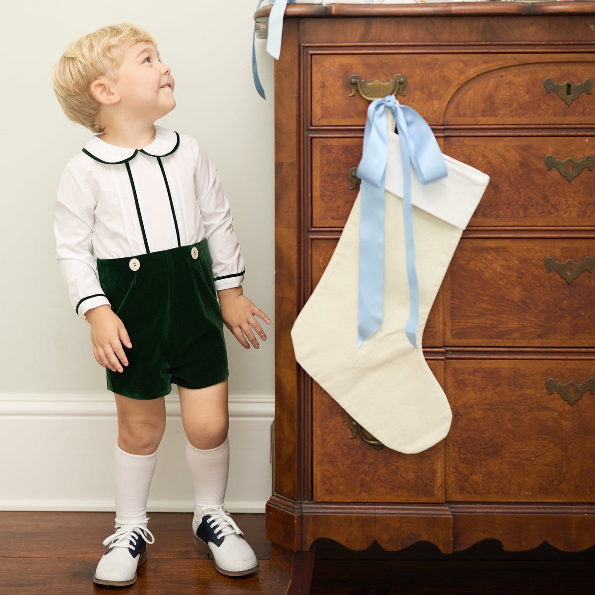 Boys’ Benjamin Button On with crisp white long-sleeve cotton poplin top, Grafton Green piping and pintuck details, paired with Grafton Green Velvet shorts and signature HD buttons.