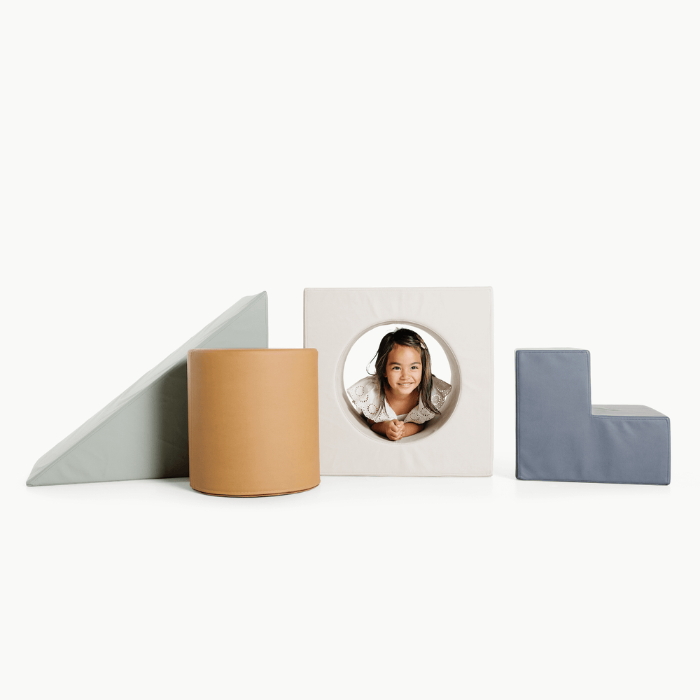 Nightfall block playset front: ramp, tan cylinder, cube tunnel with child peeking, blue L-step on white background