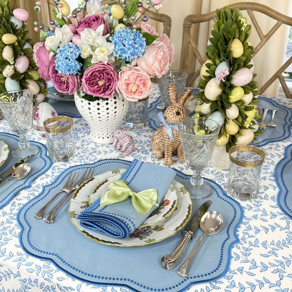 Easter-themed table setting with floral arrangements, bunny figurines, and decorative eggs.
