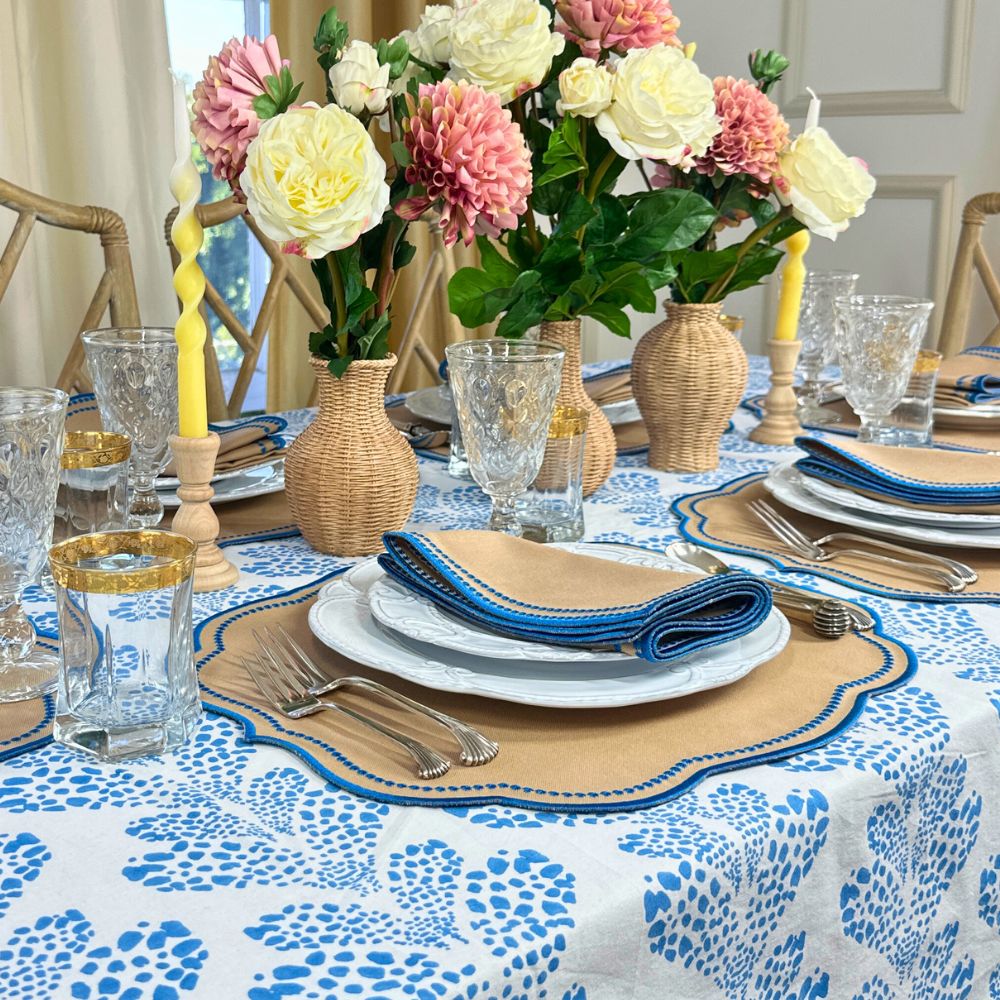 Elegant table setting with floral centerpieces, patterned tablecloth, and decorative plates. luxury embroidered placemat and napkins