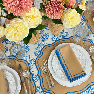 Elegant table setting with floral centerpieces, patterned tablecloth, and decorative plates. luxury embroidered placemat and napkins