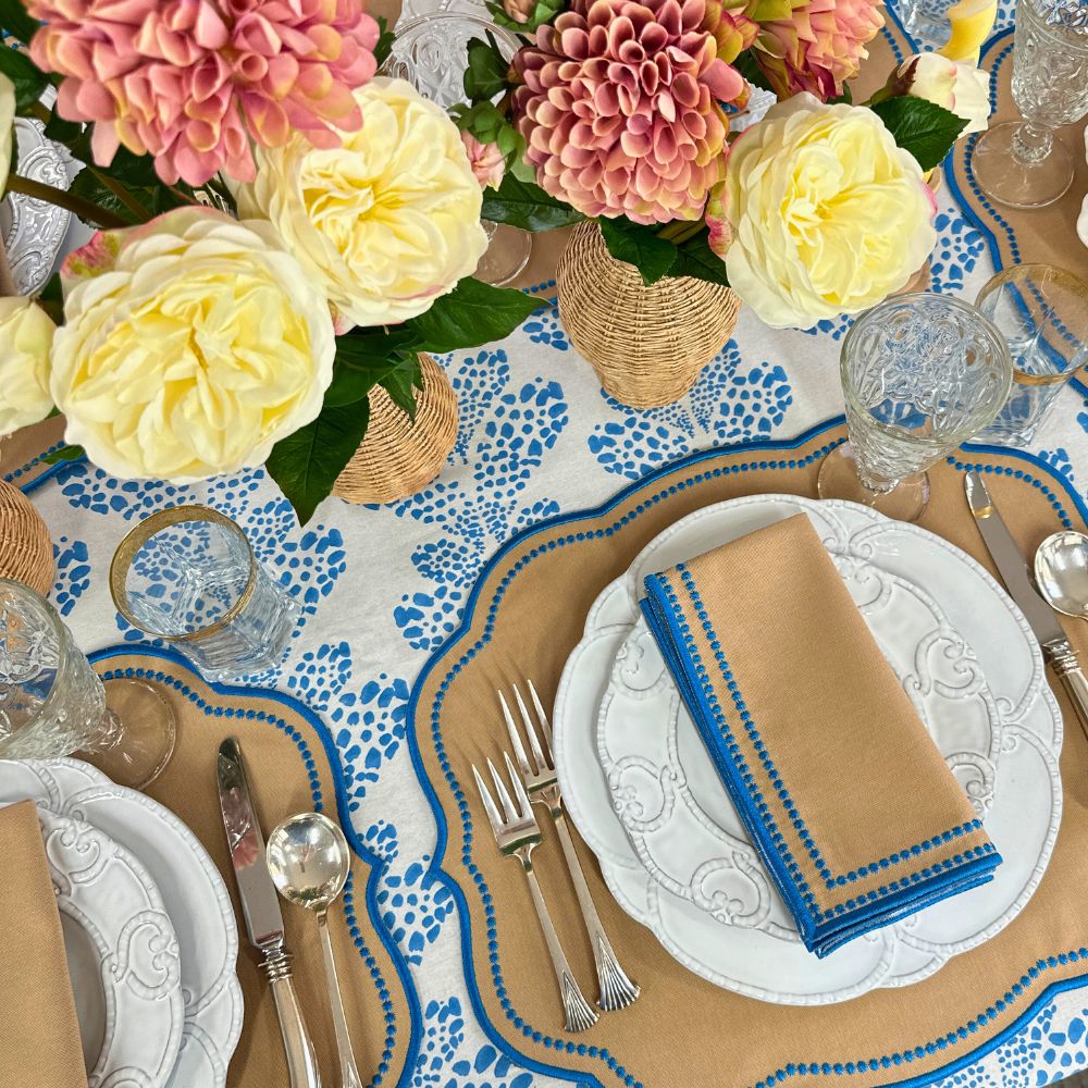 Elegant table setting with floral centerpieces, patterned tablecloth, and decorative plates. luxury embroidered placemat and napkins