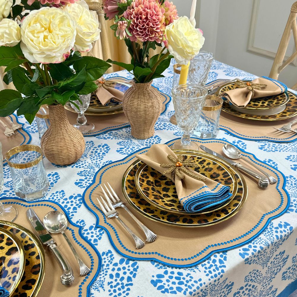 Elegant table setting with floral centerpieces, patterned tablecloth, and decorative plates. luxury embroidered placemat and napkins