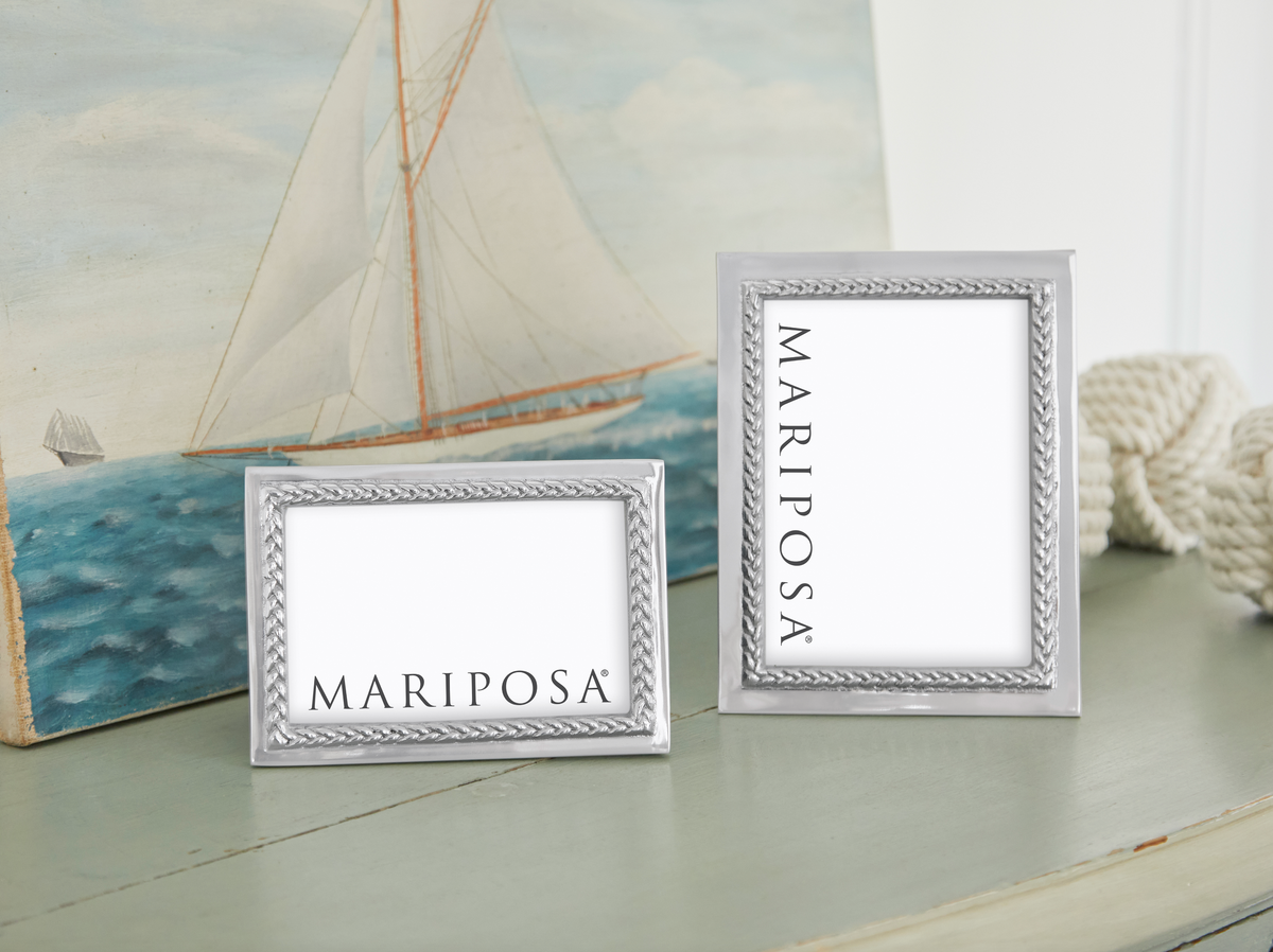Front view of two silver Mariposa braided picture frames, 4x6 and 5x7, with braided border and sailboat background