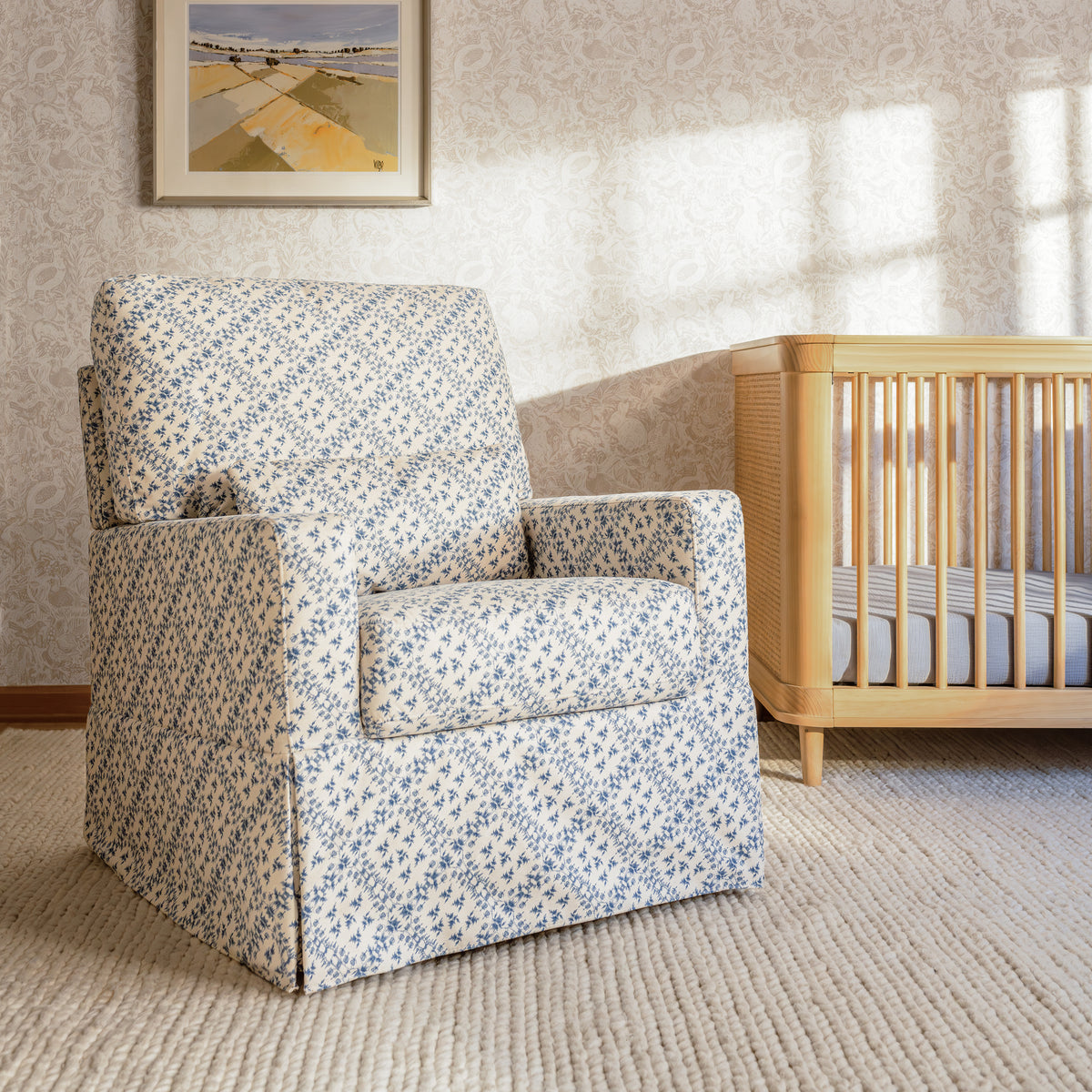 Front view of Sarah Flint x Namesake Crawford Swivel Glider showcasing blue lattice upholstery and lumbar support in a nursery
