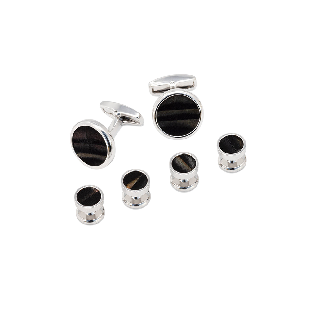 Angled front view of Chino cufflink and studs set showing natural black turkey feather inlays and polished silver finish on black background