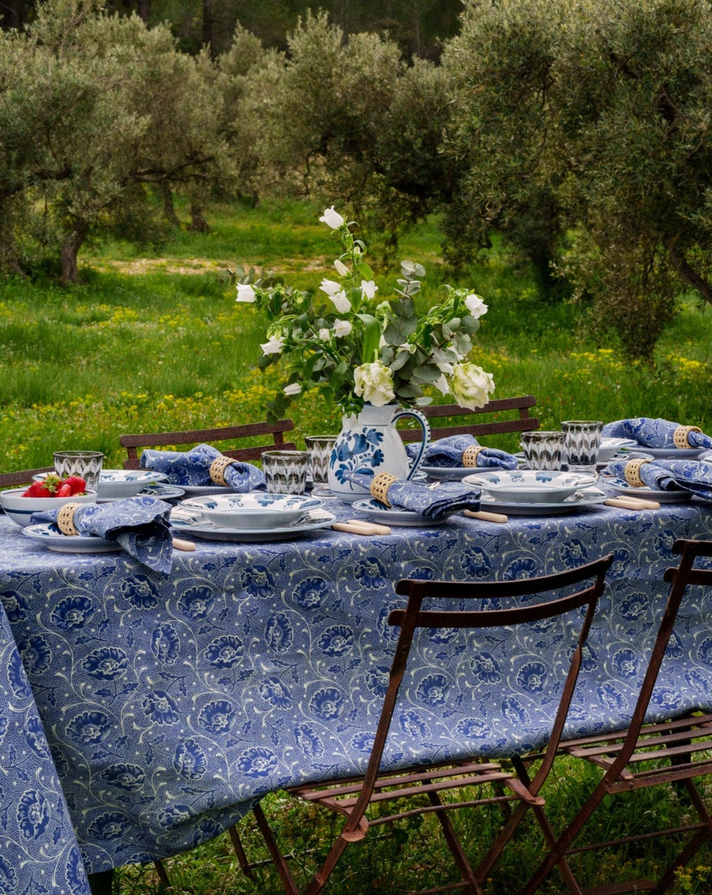 Front view of Blossom Jug, Midnight Blue showcasing blue and green floral motifs on ceramic with an outdoor tablescape background
