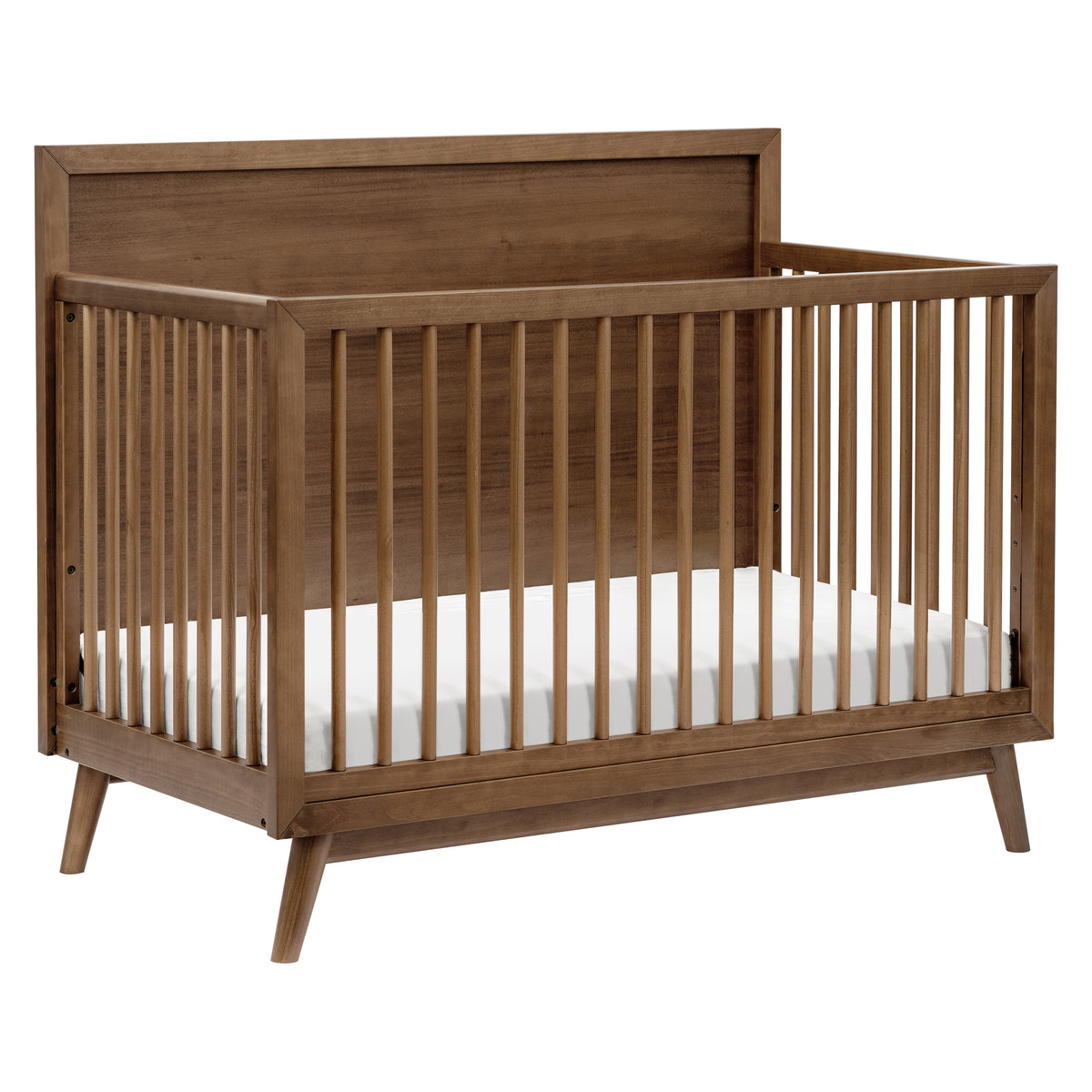 Three-quarter view of Palma 4-in-1 Convertible Crib in natural walnut showcasing high headboard and slatted sides on white background