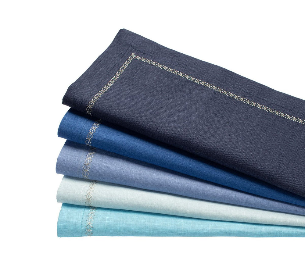 Stacked view of Classic Napkin, set of 4, in gradient blues showcasing embroidered silver star border on white background
