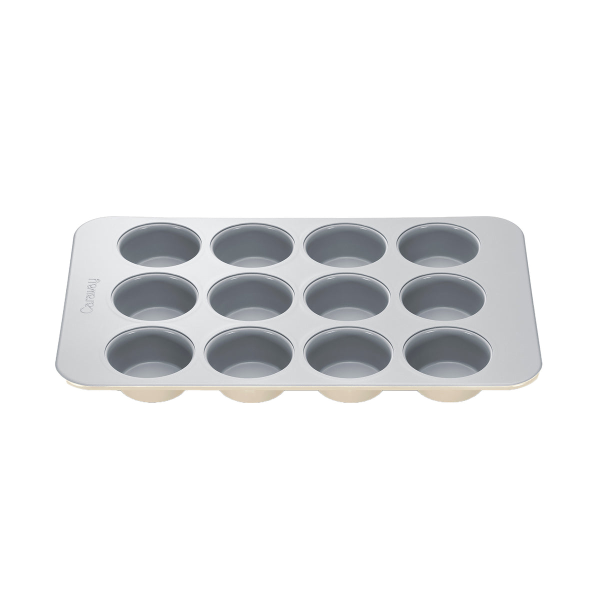 Angled top view of cream Caraway 12 cup muffin pan showing smooth nonstick ceramic coated cups on white background