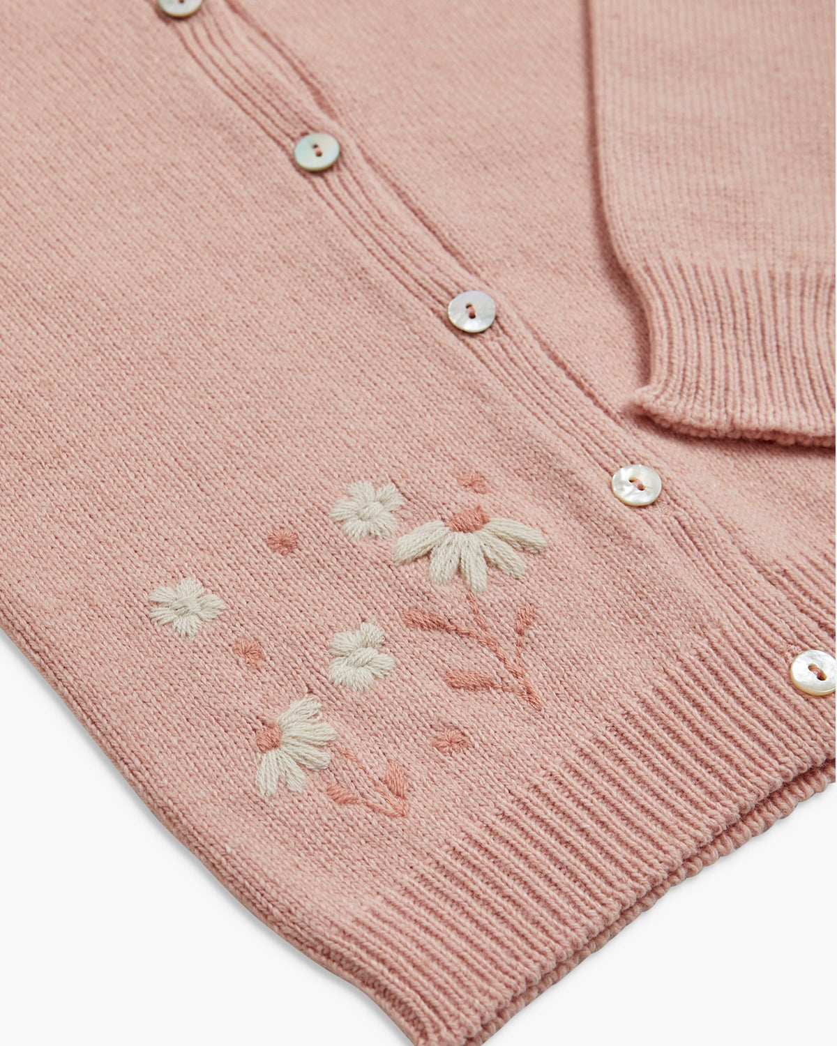 Pink knitted cardigan with floral embroidery on a white background