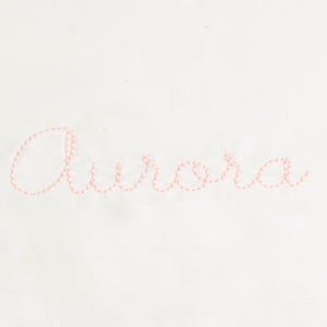 Monogram in pink color thread the name "Aurora"