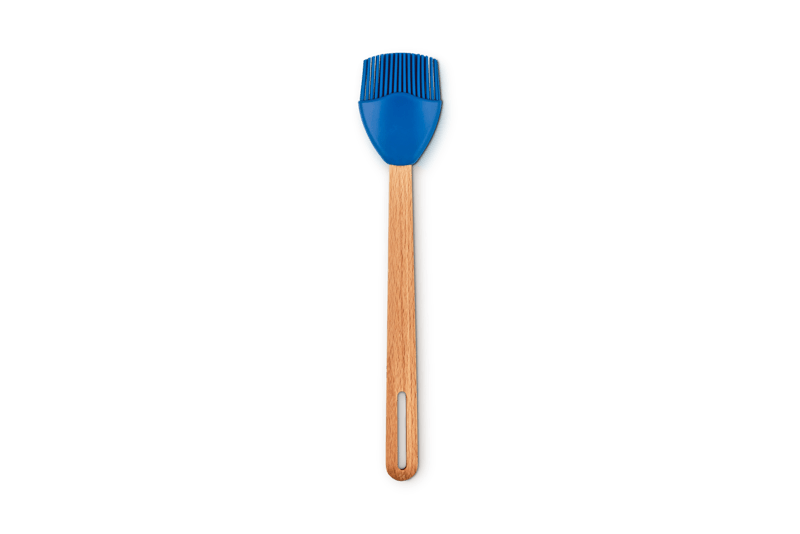 Top view of Signature Silicone Basting Brush showcasing Marseille blue crown-shaped silicone bristles and beech wood beech handle on white background