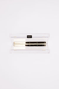 Clear Italian Mia Acrylic Clutch with Ivory Laser Cut Rose holder from The Bella Rosa Collection with a black makeup palette inside.