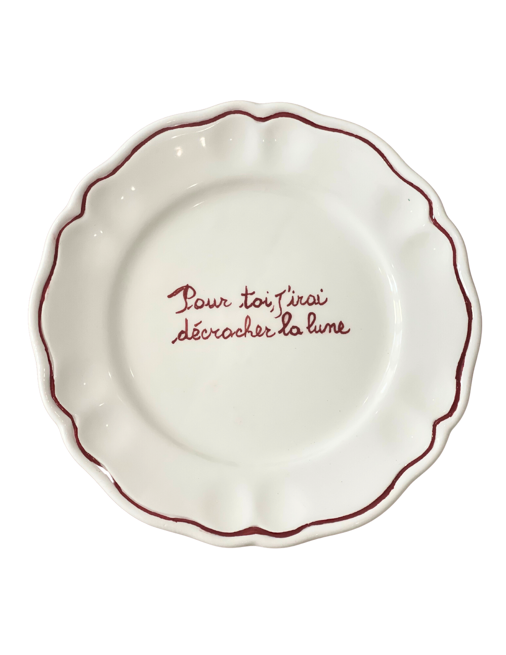 Top view of scalloped white ceramic plate Pour toi, j’irai décrocher la lune showcasing red scalloped rim and handwritten French inscription