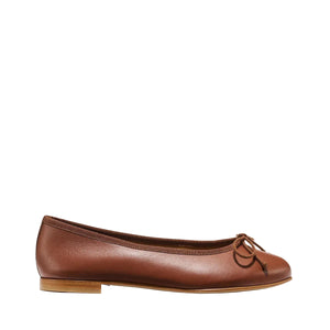 The Demi - Cognac Nappa by margaux-development is a brown leather ballet flat handmade in Spain, featuring a small bow, low wooden heel, and rounded toe, displayed on a plain light background.
