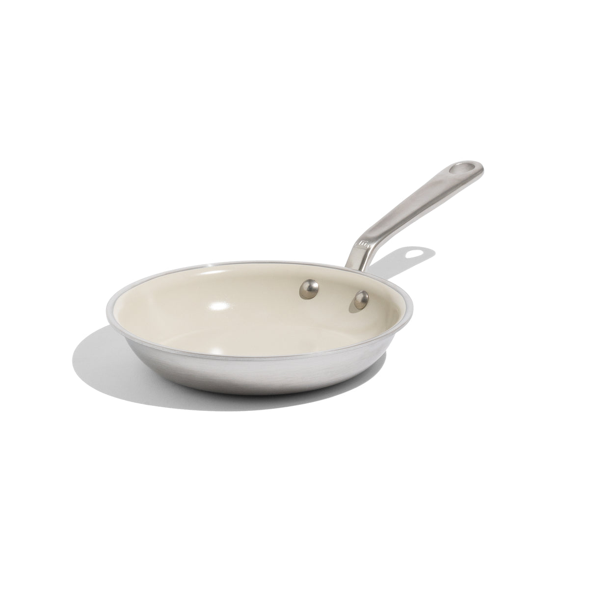 Three-quarter view of CeramiClad 8-inch non stick fry pan showcasing cream ceramic interior and long handle on white background