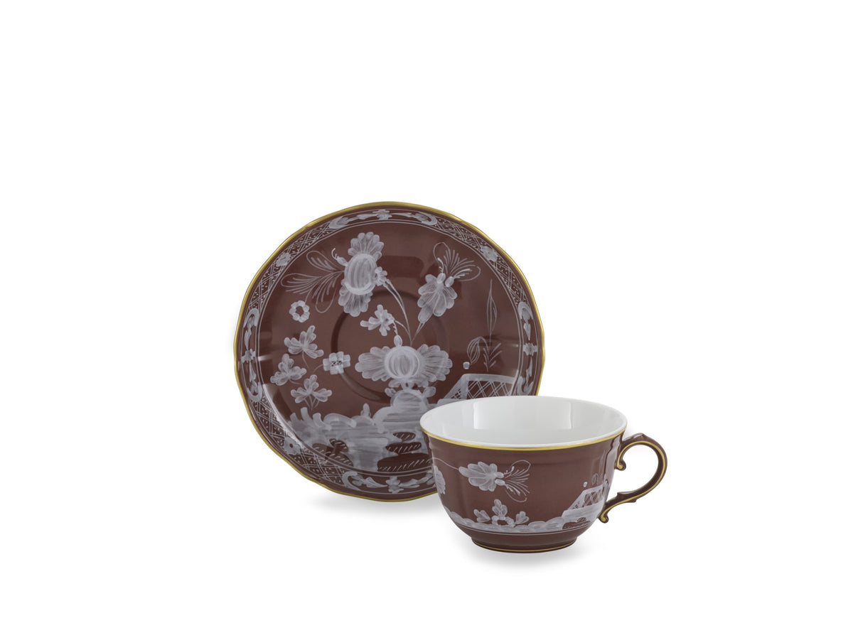 Front view of Oriente Italiano Antico Doccia tea cup in Castagna with floral motifs and gold plated rim on white background